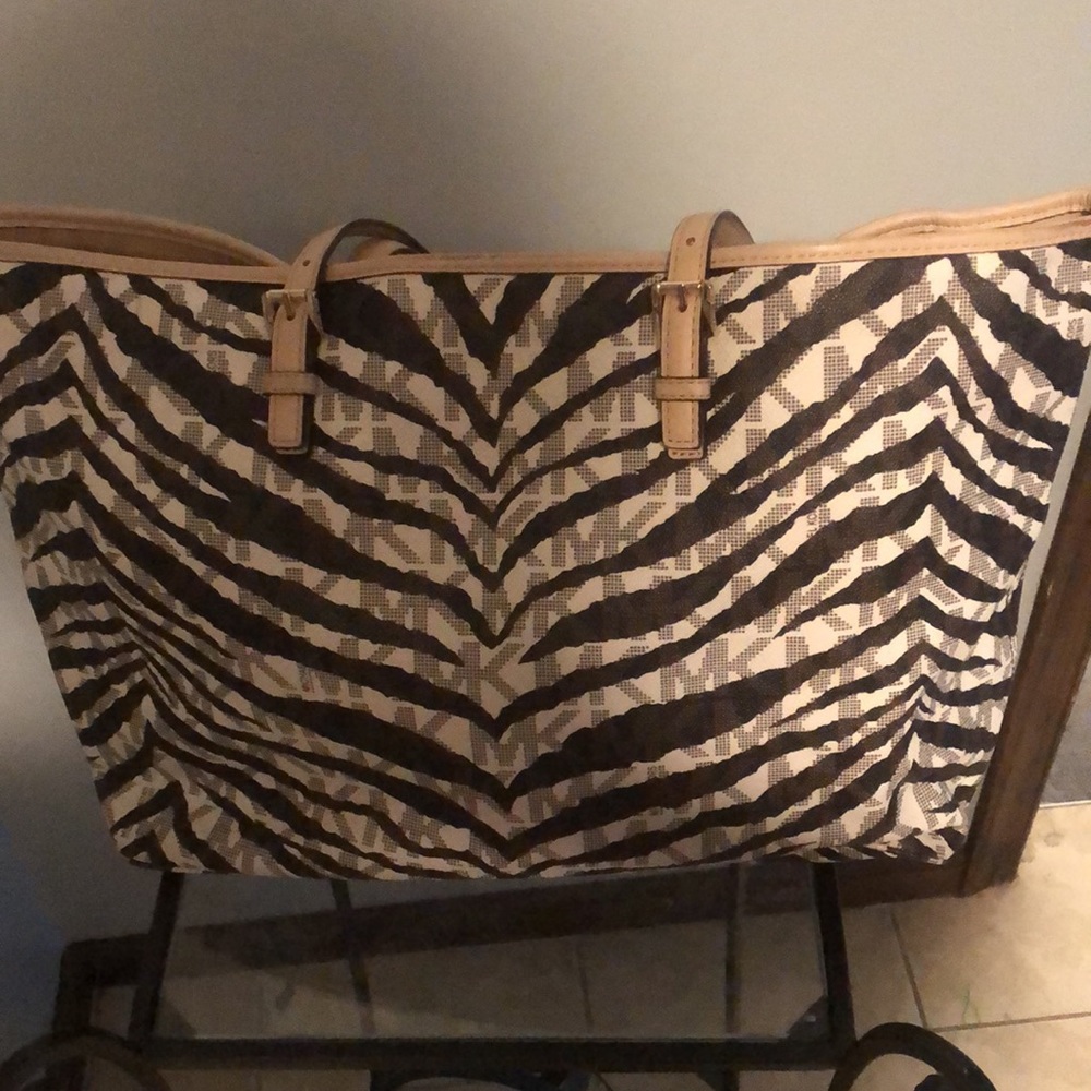 Beige and brown Michael kors purse large has slight wear on the handles